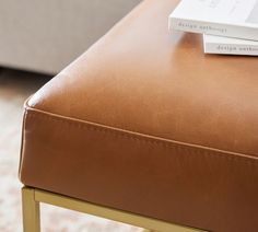 a close up of a table with a book on it and a couch in the background