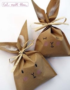 two brown paper bags with bunny faces on them, tied up to each other and sitting next to each other