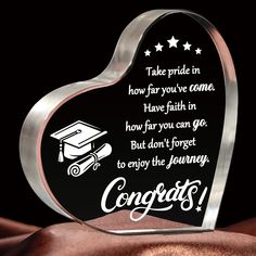 a heart shaped glass award with a graduation cap on it's back and congratulations written in