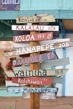 a wooden sign with many different languages on it in front of a storefront window