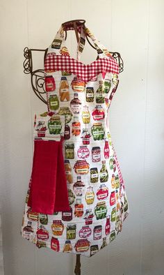 an apron is hanging on a stand with two red towels in front of the apron