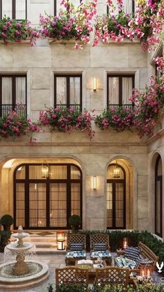 an indoor courtyard with seating and flowers on the windows