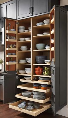 an open cabinet filled with lots of plates and bowls in the middle of a kitchen