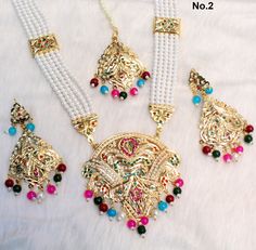 Jadau navrattan Rani Haar necklace Set embellished with pearls. Necklace length: 13 inches (including pendant) Earrings length: 2.9 inches (with drops) ; Width: 1.3 inches Multicolor Kundan Necklace For Festive Occasions, Multicolor Chandbali Necklaces For Eid, Multicolor Kundan Necklace For Festive Eid Occasions, Festive Multicolor Kundan Necklace For Eid, Multicolor Bollywood Kundan Necklace For Eid, Traditional Multicolor Necklaces For Eid, Traditional Long Meenakari Bridal Necklace, Multicolor Necklace For Eid And Gifts, Multicolor Kundan Necklace For Eid