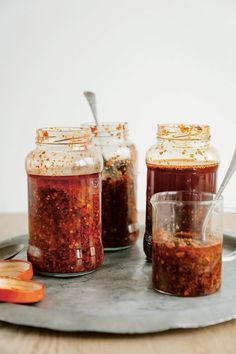 three jars filled with food sitting on top of a metal tray