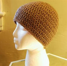 a mannequin head wearing a brown crocheted beanie hat on display