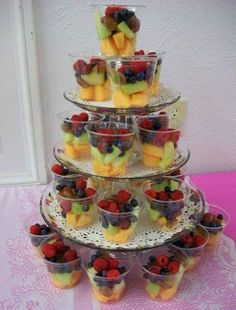 a tiered cake with fruit cups on it