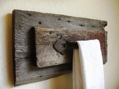 an old wooden towel rack with two towels hanging from it's sides and a hook in the middle