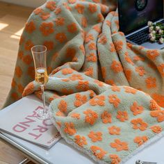 an open laptop computer sitting on top of a bed next to a glass of wine