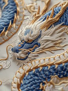 blue and gold dragon embroidered on white fabric