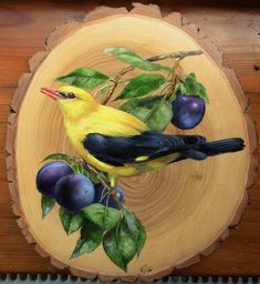 a yellow bird sitting on top of a piece of wood next to plums and leaves