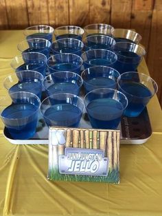 there are many cups on the table with blue liquid in them and a sign that says junklington jello