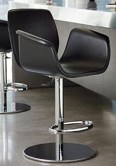 two black chairs sitting next to each other on top of a metal floored area