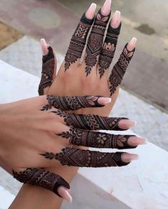 two hands with henna tattoos on them