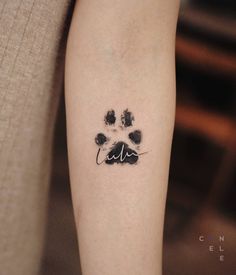 a dog paw tattoo on the left arm