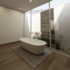 a bathtub sitting on top of a wooden floor next to a wall with windows