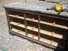 an old dresser is being worked on with some wood and sand in the back ground