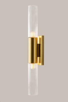 a gold and clear wall light on a gray background