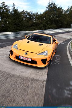 an orange sports car driving down the road