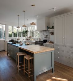 a kitchen with two stools in front of an island and counter top on the other side