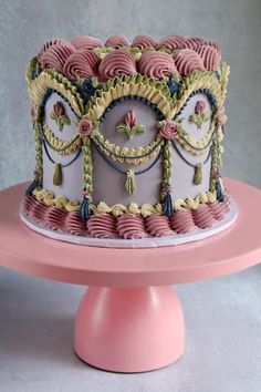 a fancy cake on a pink pedestal with white frosting