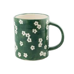 a green mug with white flowers on it