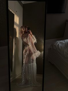 a woman is taking a selfie in the reflection of a mirror while wearing a dress