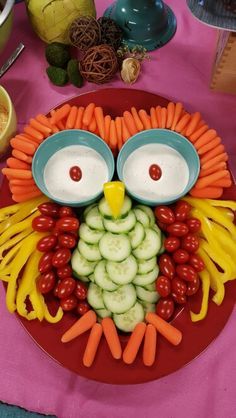 an owl made out of vegetables and carrots on a plate with other food items