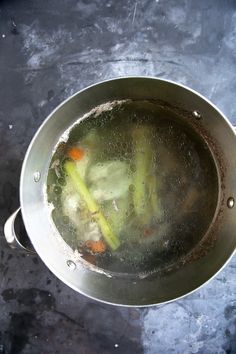 a metal pot filled with vegetables on top of a table