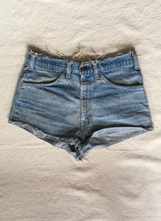 "1970s cut off jean shorts Levis 645 made in USA orange tab zip fly frayed raw waist and hem authentic age wear hem is folded up and hemmed w/fray showing label size unreadable measures, lying flat, waist-16\" rise-12\" inseam-1 hem-11\" total length-11\"" Vintage High-waisted Jean Shorts For Spring, Retro Cutoff Bottoms For Summer, Retro Cutoff Shorts For Spring, Summer Retro Cutoff Bottoms, Spring Retro Cutoff Shorts, Retro Cotton Cutoff Shorts, Fitted Cotton Cutoff Jean Shorts, Vintage Cutoff Shorts For Summer, Vintage Denim Jean Shorts For Summer