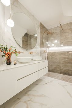 a bathroom with two sinks and a large mirror on the wall next to each other