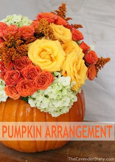 a pumpkin filled with flowers on top of a wooden table