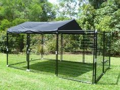 a black dog kennel in the grass