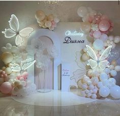 a room with balloons and flowers on the wall, decorated in white and pink colors