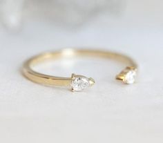 a gold ring with two diamonds on it