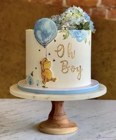 a winnie the pooh birthday cake with flowers and balloons is on top of a table