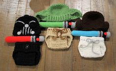 several crocheted hats and mittens laid out on a wooden floor