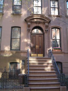 the stairs lead up to the front door of this brownstone house