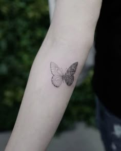 a small butterfly tattoo on the left inner arm and wrist, it is black and white