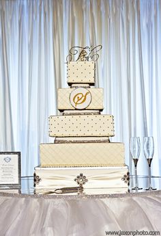 a wedding cake sitting on top of a table next to wine glasses and an award plaque