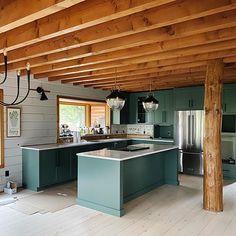 an open kitchen with green cabinets and wood beams on the ceiling is pictured in this image