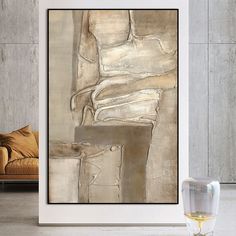 a painting hanging on the wall next to a glass of wine