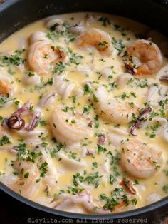 a pan filled with shrimp and cheese on top of a table