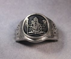 This ring was designed with the Image of Lord Shiva Om Namah Shivaya The beautiful pewter ring is a silver color and the background is blackened to bring out the fine detail of the design. Our rings are 100% Lead and nickel free pewter and made in the USA The top design part of the ring measures about 15 mm in diameter The ring band tapers from about 15mm to about 4.5mm at the bottom and is about 1.75mm thick We offer free shipping within the USA Rings are available in sizes 7 to 14 Spiritual Silver Jewelry With Antique Finish, Adjustable Antique Silver Jewelry, Silver Rings With Antique Finish, Silver Antique Finish Rings, Silver Ring With Antique Finish As A Gift, Silver Rings With Antique Finish As Gift, Silver Rings With Antique Finish For Gifts, Vintage Silver Ring With Antique Finish, Silver Metal Rings For Ceremonial Occasions