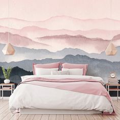 a bedroom with mountains painted on the wall and pink bed linens in front of it