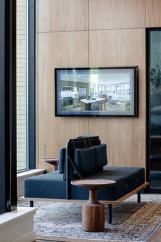 a living room with couches and a television mounted on the wall