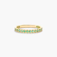 Crafted in 14K yellow gold, this contemporary band featuring bezel set round-cut emeralds with delicate milgrain detail is chic and timeless. Wear this brilliant band on its own or mix and match with other stackables for a fashion forward look. Elegant Emerald Ring With Bezel Setting, Elegant Emerald Ring With Smooth Bezel For Anniversary, Luxury Yellow Gold Stackable Emerald Ring, Luxury Stackable Yellow Gold Emerald Ring, Elegant Gold Emerald Ring With Smooth Bezel, Birthstone Wedding Band, May Birthstone, Types Of Gemstones, Engagement Bands