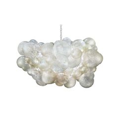 a white chandelier hanging from a chain on a white wall with lots of bubbles