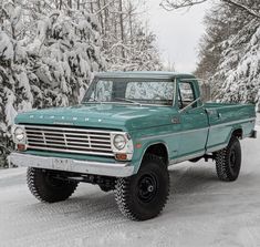 a green truck is parked in the snow