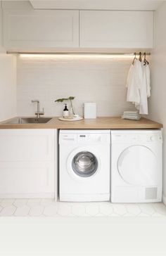 a black dog standing in front of a washer and dryer